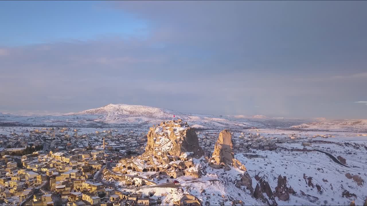 Drone Aerial View of Uchisar City, Cappadocia Turkey. Mountain Castle With Caves and Winter Landscape on Golden Hour Sunlight