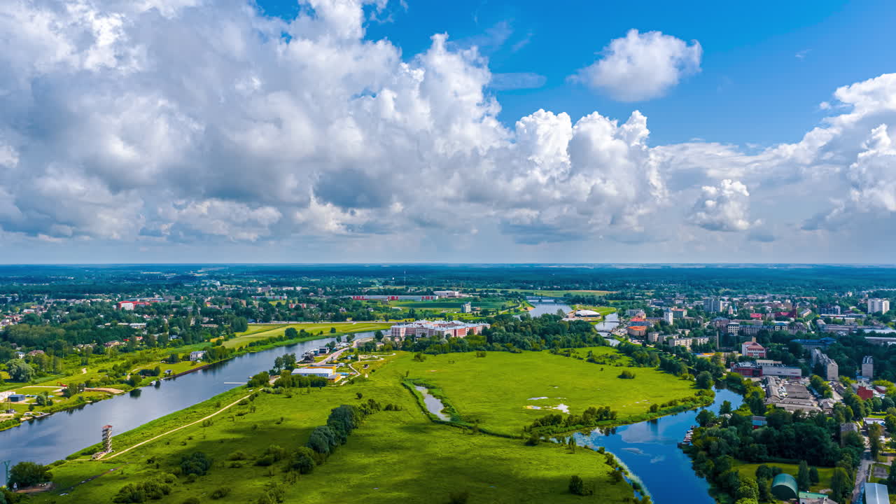 Cloudscape aerial time lapse over the idyllic Latvian city state village of Jelgava along the Liepupe River