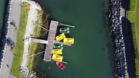 Pequeño-Estanque-De-Agua-De-Mar-Dentro-Del-Rompeolas-Y-Kayaks-Tendidos-En-El-Césped-Listo-Para-Usar---Antena-De-Ojo-De-Pájaro-De-La-Costa-De-Loen-Con-Equipo-Deportivo---Noruega