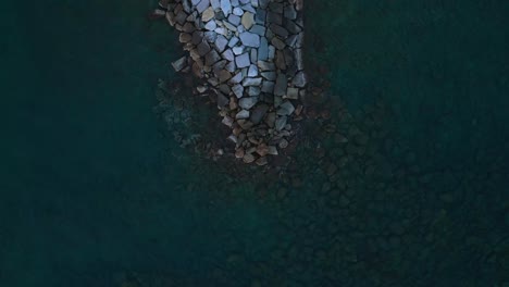 aerial overhead view of waves crashing into breakwater at varazze, itlay