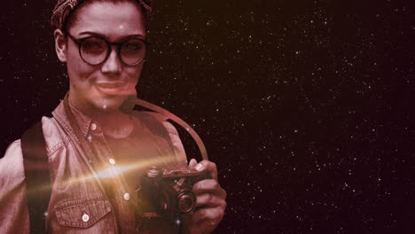 espacio sobre la mujer con cámara digital contra las estrellas brillando en el fondo