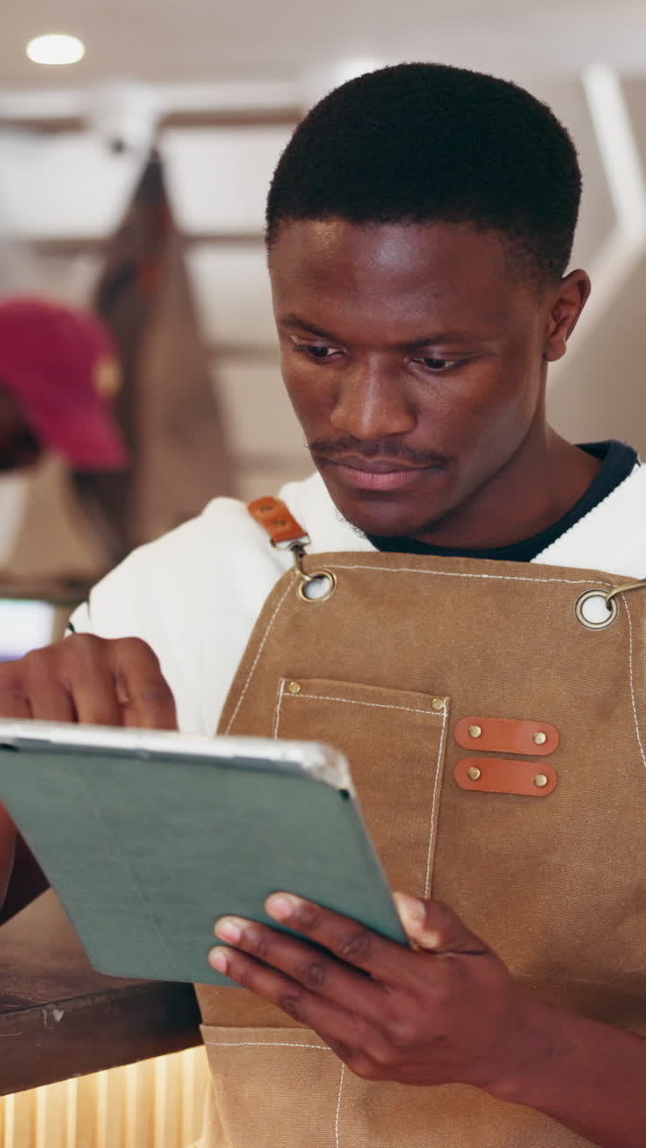 Man using a tablet while wearing an apron