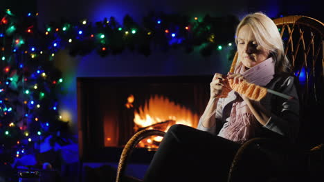 evening by the fireplace before christmas - a woman knits warm clothes 4k video