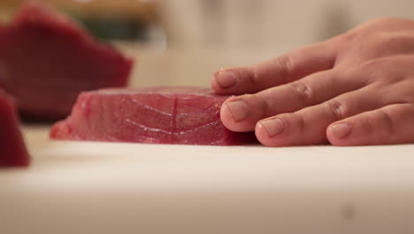 Chef-Cutting-A-Fresh-Tuna-Fillet-On-A-Chopping-Board-Using-A-Sharp-Knife