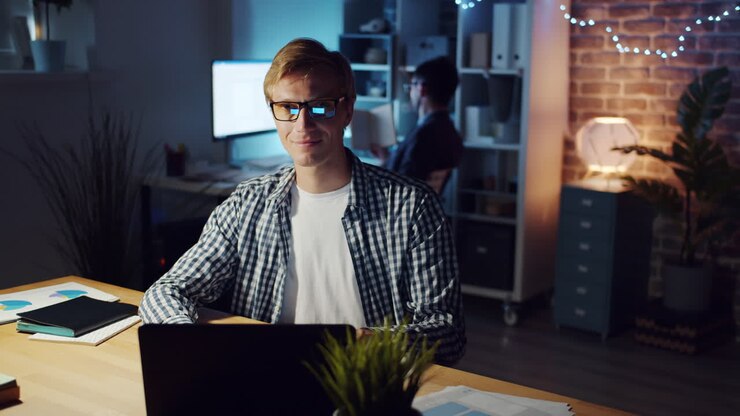 Mann arbeitet bis spät in die Nacht am Laptop im Büro