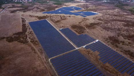 Enorme-Central-De-Energía-Solar,-Vista-Aérea-Sobre-Paneles-Solares-Y-Campos-Rurales