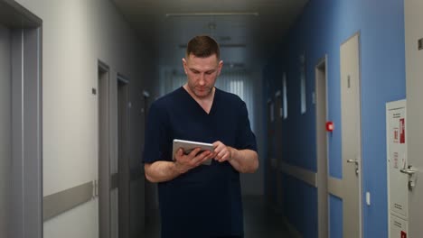 doctor using tablet in hospital hallway