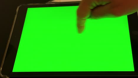 man works on tablet green screen in office