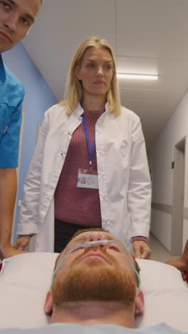 medical personnel assisting patient in hospital corridor