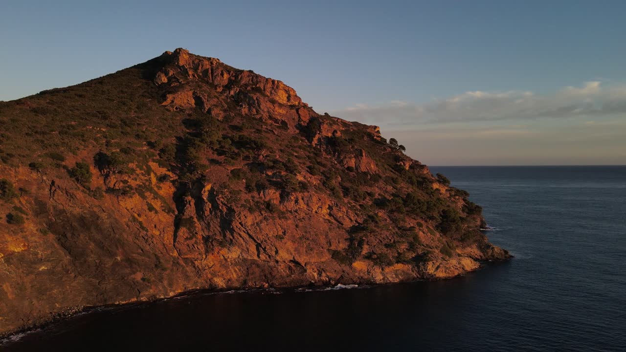 imágenes de drones de un acantilado junto al mar a lo largo de la costa del mar mediterráneo mientras está bellamente iluminado por la puesta de sol