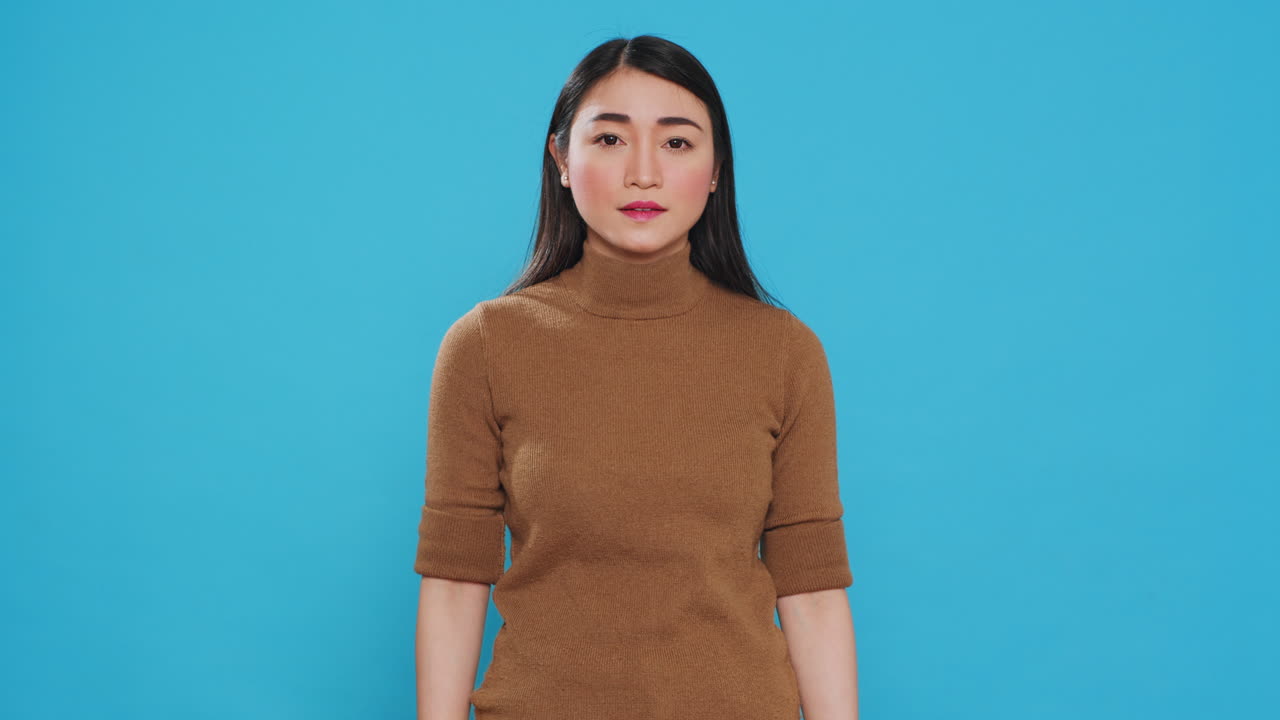 Asian professional maid smiling at camera after finishing house cleaning