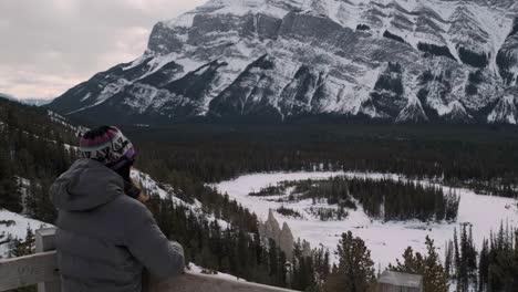 hiker girl takes in the amazing scenic view at mount rundle in banff, tilt up