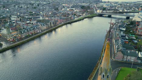 Sie-Fliegen-Dicht-Am-Alten-Hohen-Kirchturm-Vorbei-Und-Blicken-Entlang-Des-Flusses-Ness