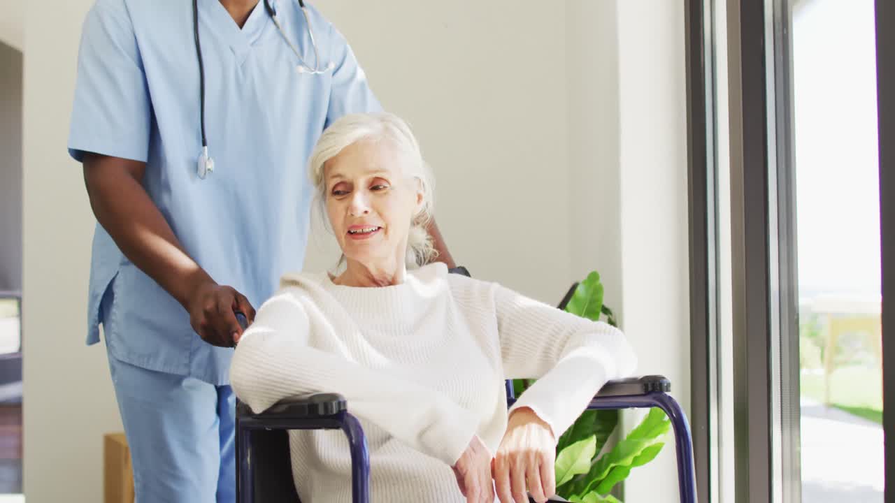 Video of midsection of african american male doctor taking care of caucasian senior woman