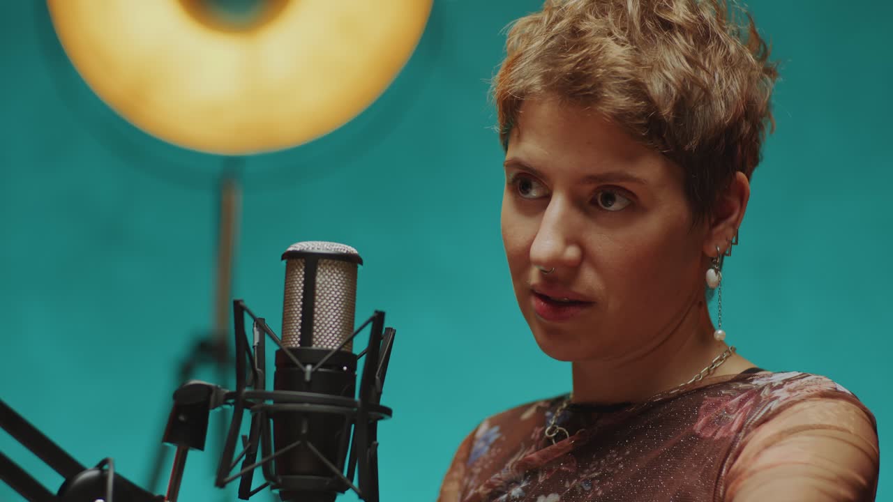 Young Woman Giving Podcast Interview in Modern Recording Studio
