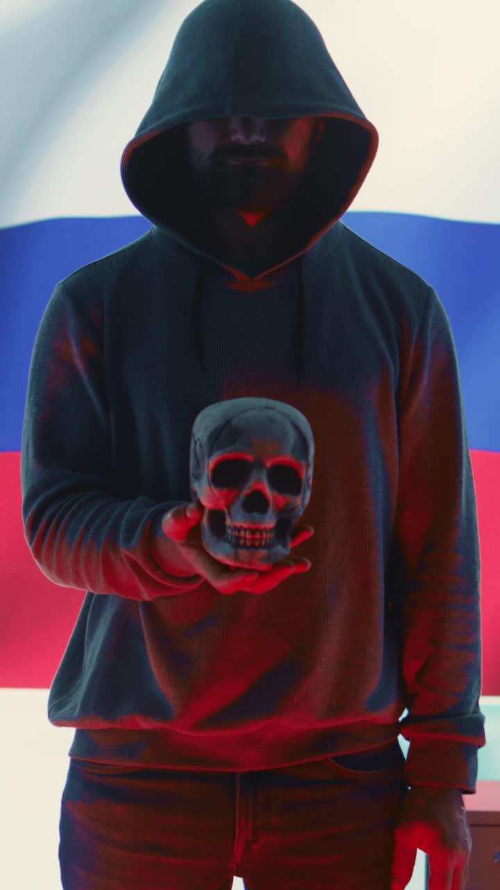 Mystisk mand med hætte, der holder kranium mod russisk flag