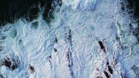 Slow-Motion-of-Ocean-Waves-with-Top-Down-View-of-White-Water-Splashing-Over-Rocks