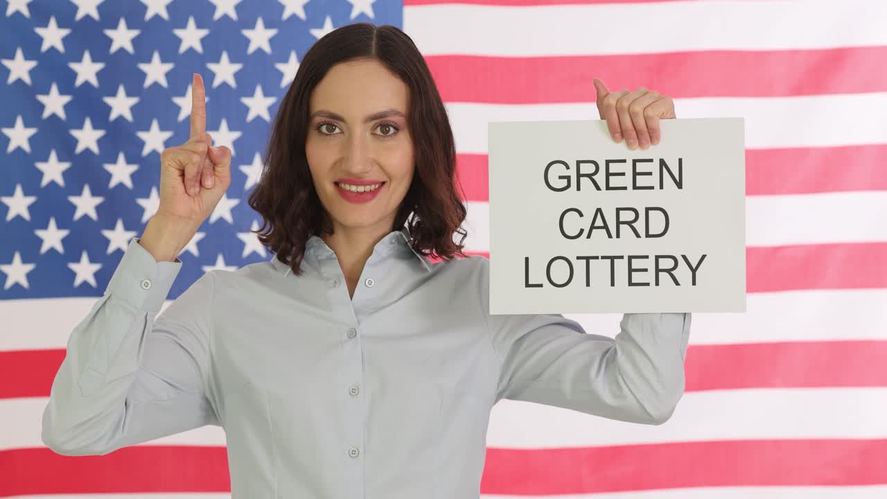 Woman holding 'GREEN CARD LOTTERY' sign in front of an American flag