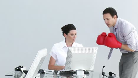 Competitive-businessman-talking-to-his-colleague-wearing-boxing-gloves