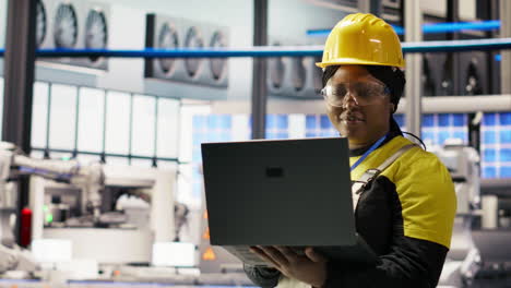 vertical video woman working in industry 4.0 plant using notebook, doing maintenance