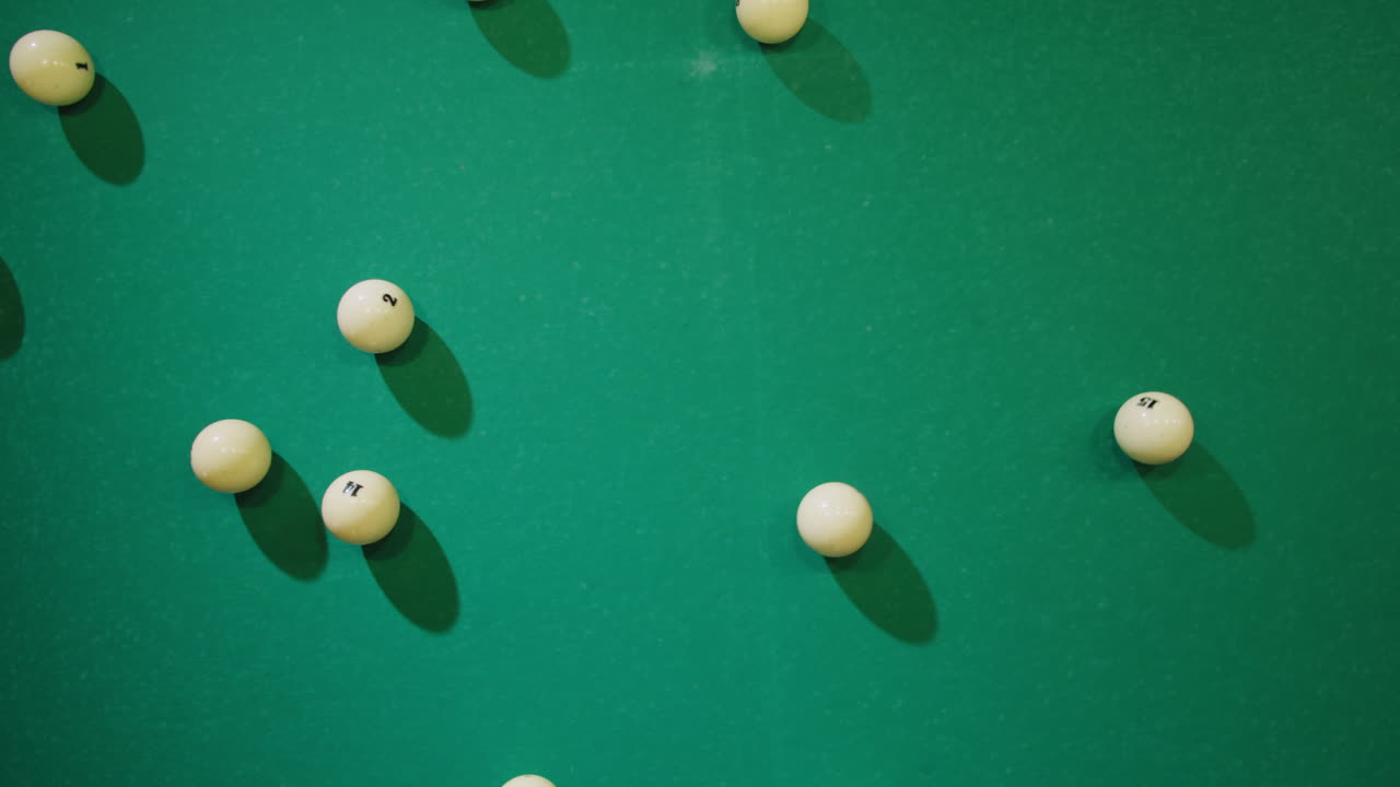 Breaking white pool balls top view on green billiards table for start to play. Russian biliard game, Russian pyramid. Billiard balls with numbers on a pool table. Billiards team sport. High quality 4k footage