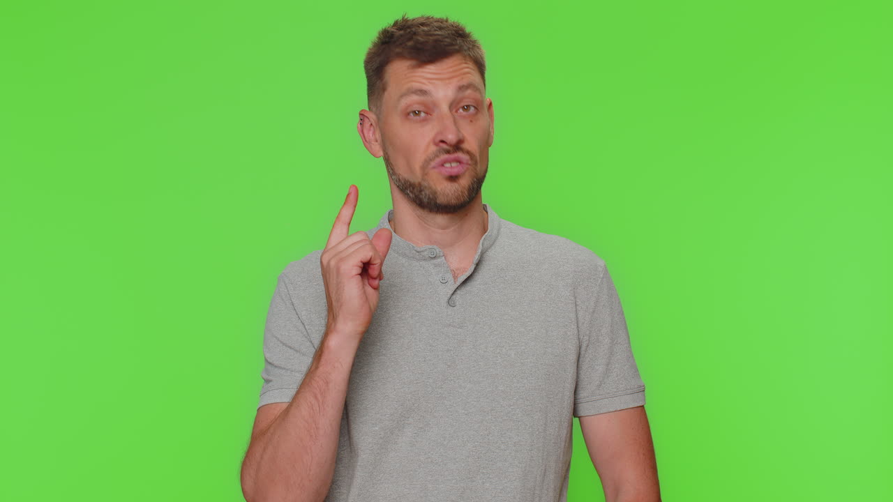 hombre joven guapo apuntando a la cámara y mirando con expresión alegre y lúdica, haciendo una elección