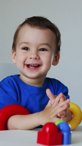adorable kid holding the rings from pyramid on his hands. beautiful child smiling to the camera. vertical video