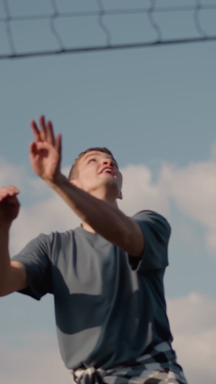 sesión de entrenamiento de voleibol con un individuo que se prepara para servir mientras otros miran en el fondo, actividades deportivas que ocurren en el trasfondo, capturando la dinámica del equipo y la atmósfera deportiva