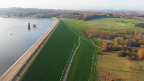 Luftdrohne-4k-Vorwärtsbewegung-über-Damm-Und-Stausee-Mit-Gehweg-Und-Wanderern