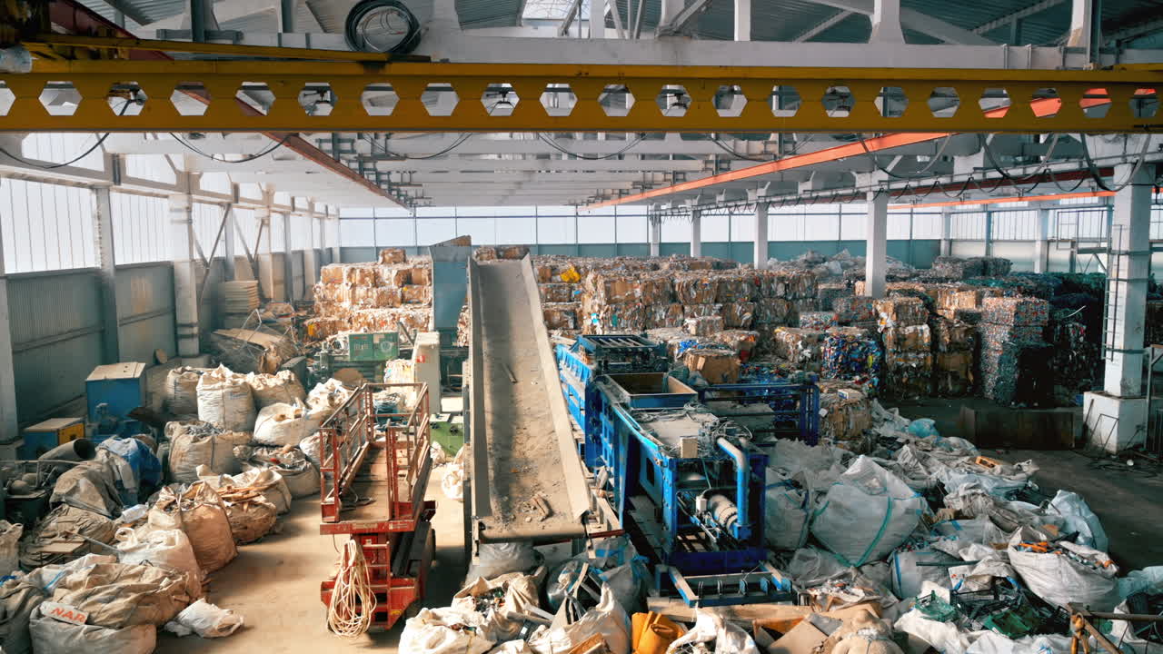 View of interior of a waste sorting plant. Cubes of compressed garbage, special tools