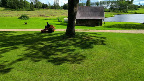 Man Mowing Lawn on a Sunny Summer Day in the Countryside