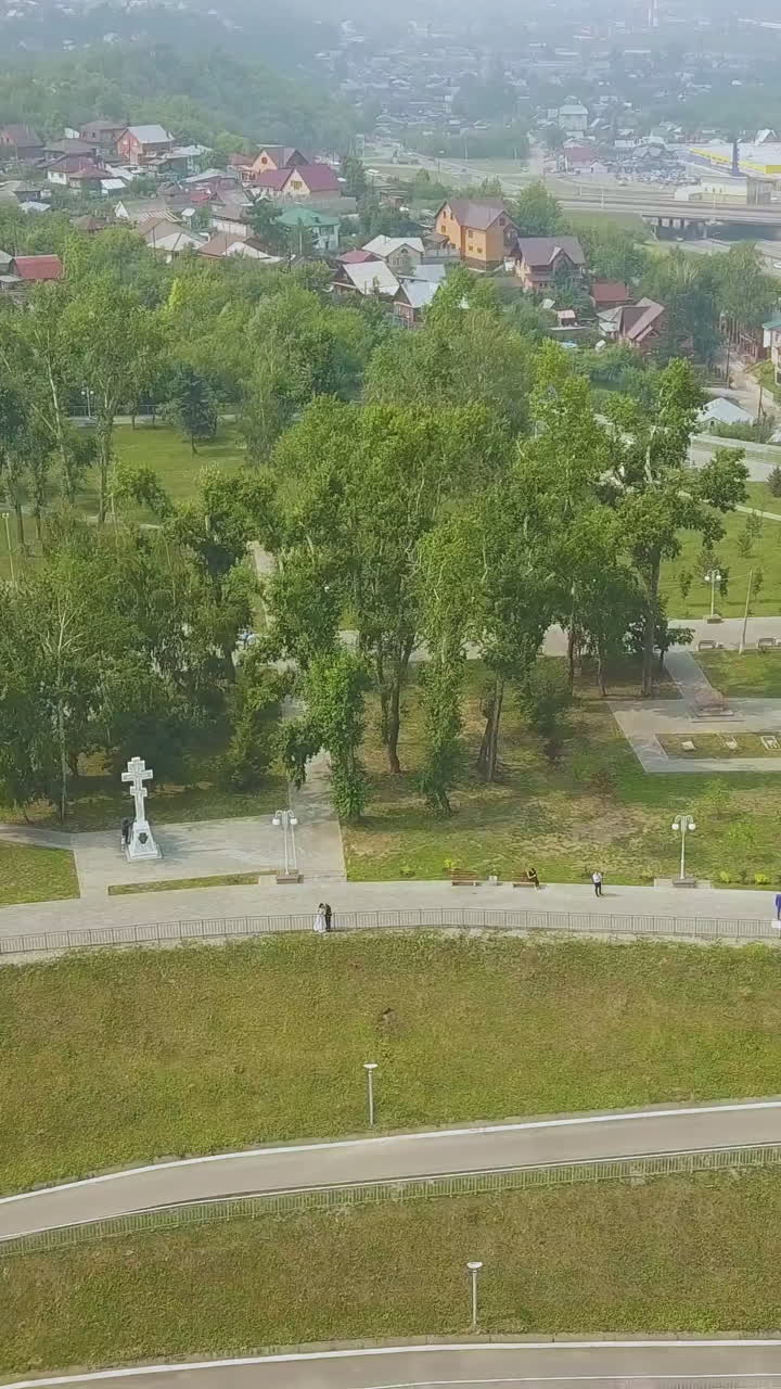 just married couple kisses near beautiful christian church in green park on nice sunny day aerial view