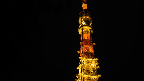 tilt shot of the tokyo tower, at night time, in minato city, japan