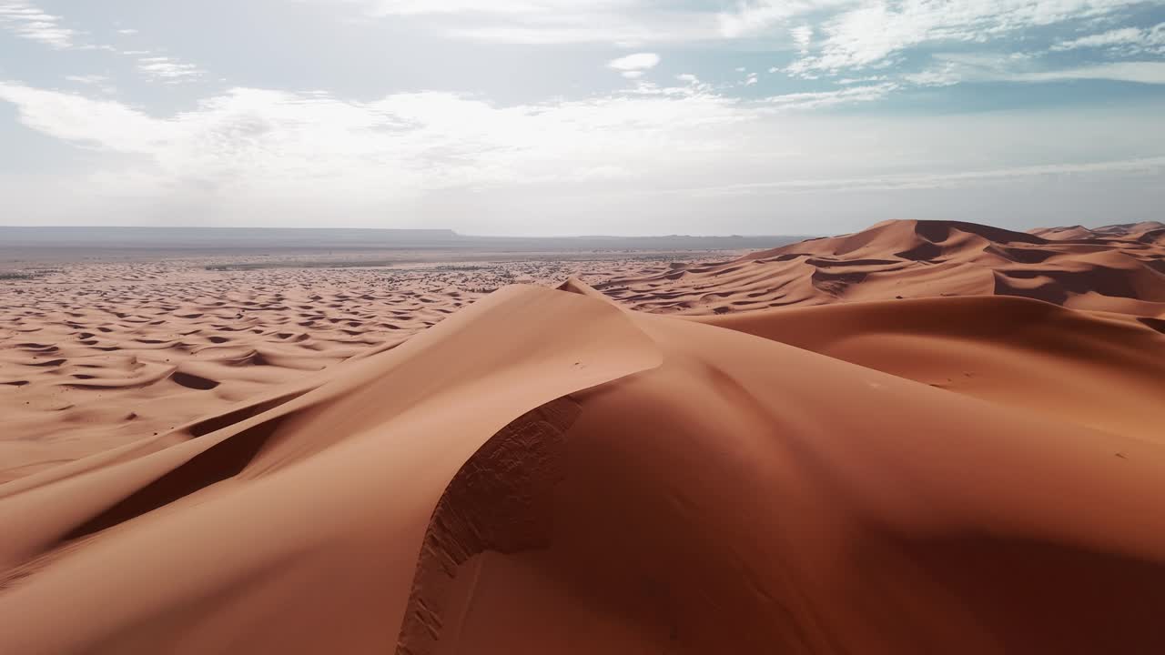 Reveal drone shot over big sandy dunes in morocco desert