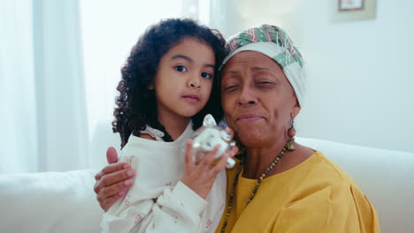 happy black grandmother and little girl hugging and smiling on camera