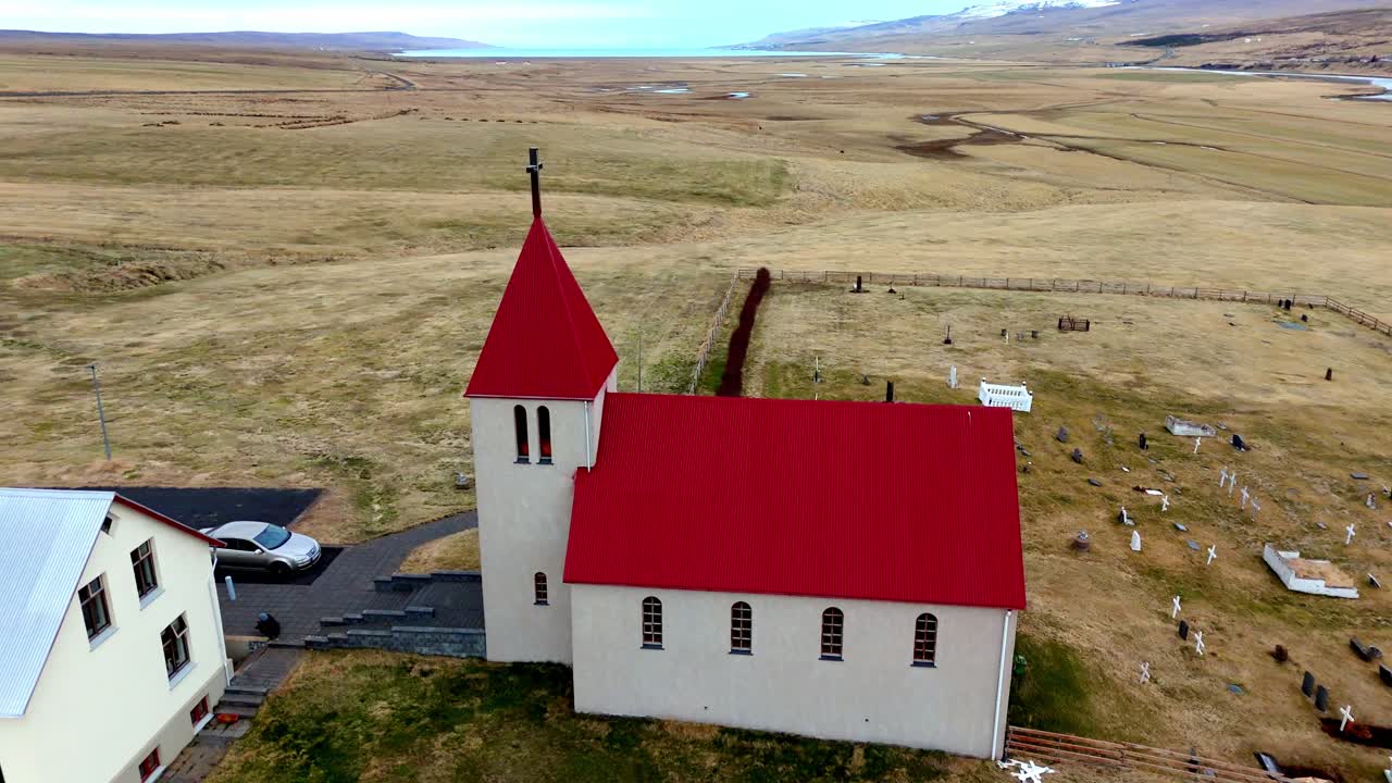 Aerial view of a small remote church in Iceland surrounded by dramatic landscapes