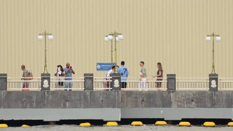 pedestrians walking on a riverside promenade