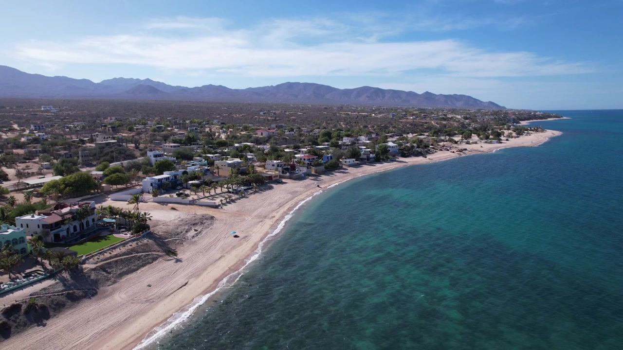 Pemandangan udara drone dari pantai berpasir dan perairan pesisir biru kehijauan di sepanjang garis pantai indah Baja California Sur, Meksiko.