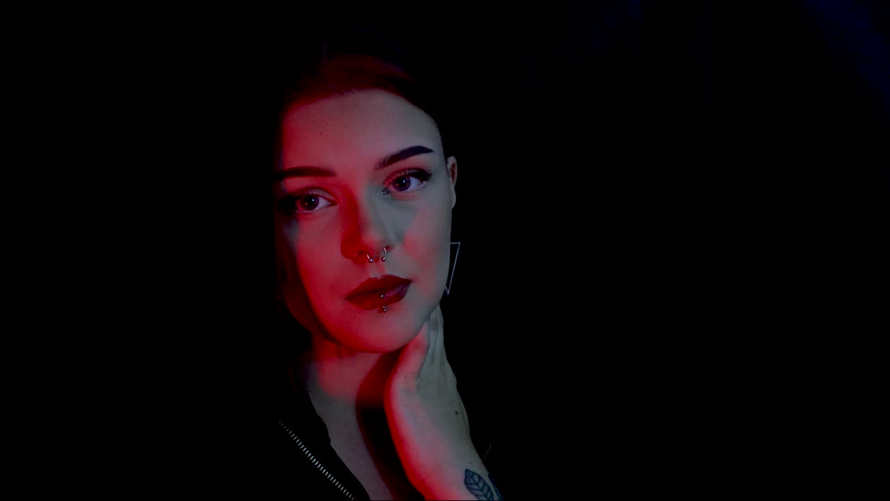 Giovane modella attraente in posa davanti a uno sfondo nero con illuminazione rossa