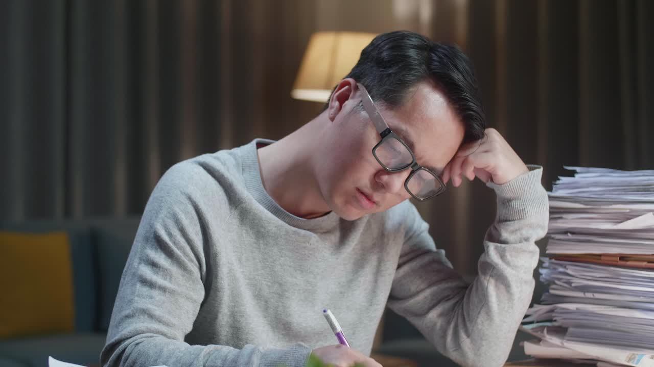 집에서 문서와 함께 열심히 일하는 동안 는 피곤한 아시아 남자의 근접