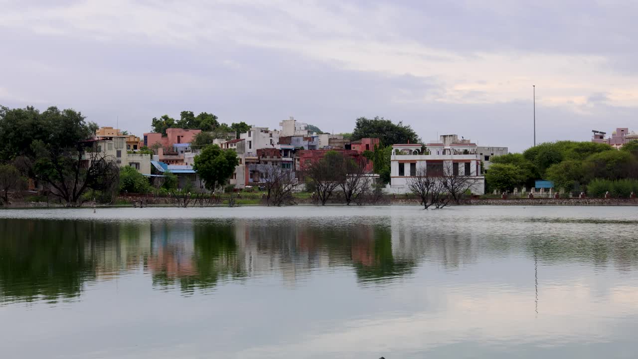 Serene Lake with city View and water Reflections Under Bright Sky at morning