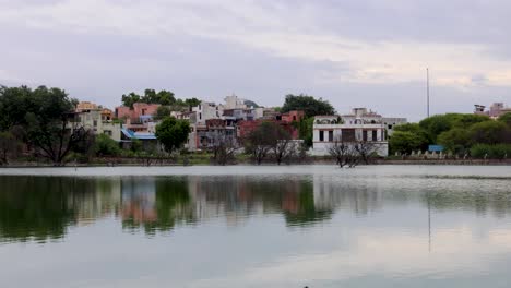 serene lake with city view and water reflections under bright sky at morning