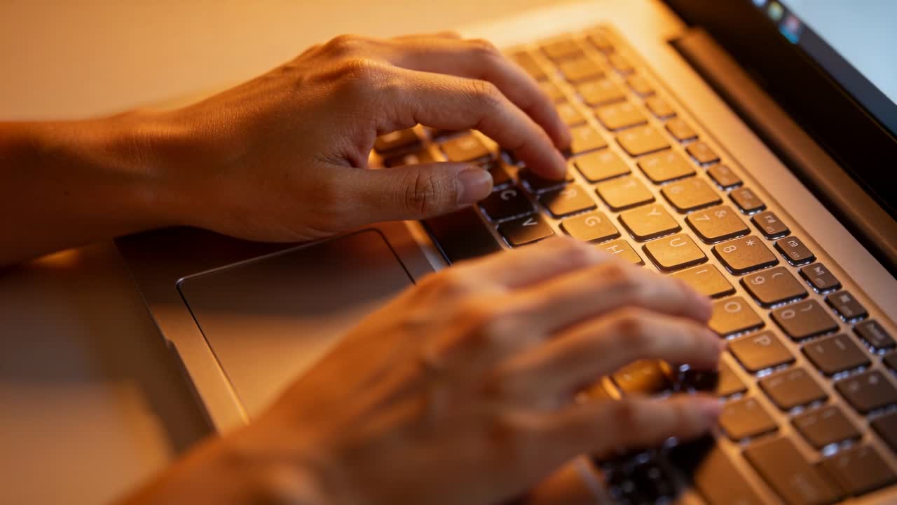 Vertical video: Lowering hands and typing on laptop keyboard at desk to finish work