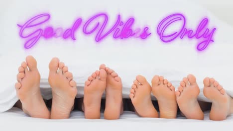 Good-vibes-only-graphic-in-pink-neon-above-the-feet-of-four-people-lying-down