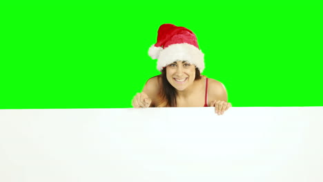 Beauty-brunette-in-santa-hat-showing-white-poster