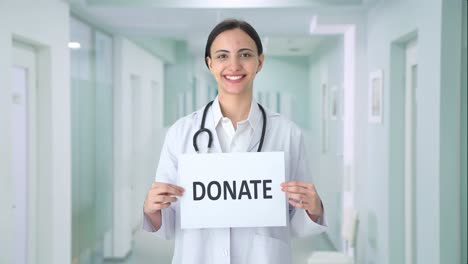 doctora india feliz sosteniendo una pancarta de donación