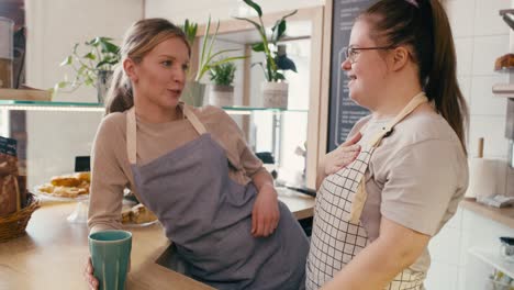 down syndrome girl chatting with her workmate in the cafe