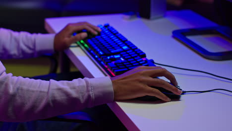 person gaming at a desk with a keyboard and mouse