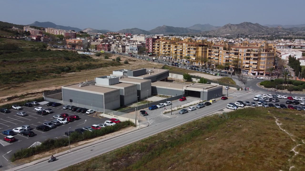 Vista aérea cenital estática con dron del centro de salud y aparcamiento de Aspe en Alicante, España. Exterior de un centro de atención sanitaria pública