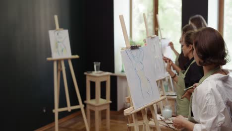 Mujeres-Encantadoras-Pintando-Silueta-Femenina-Sobre-Lienzo-En-El-Taller